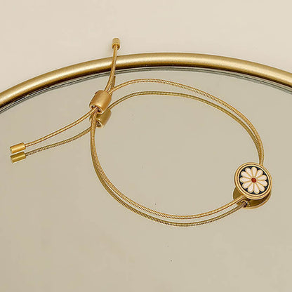 Pulsera con flor de margarita y cordón de acero dorado